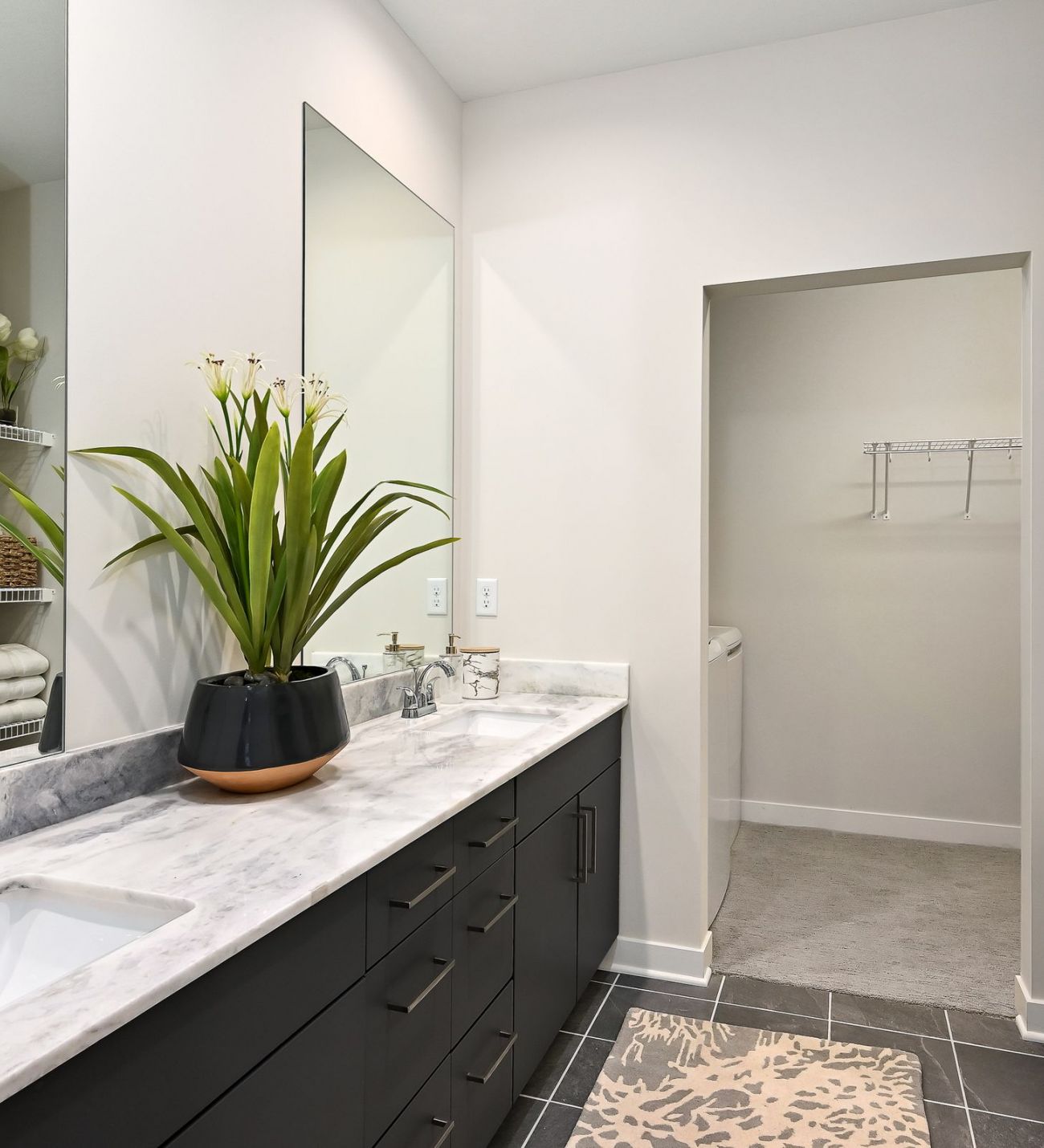 The District Flats apartment bathroom with white marble counter top and dual sinks, and modern finishes