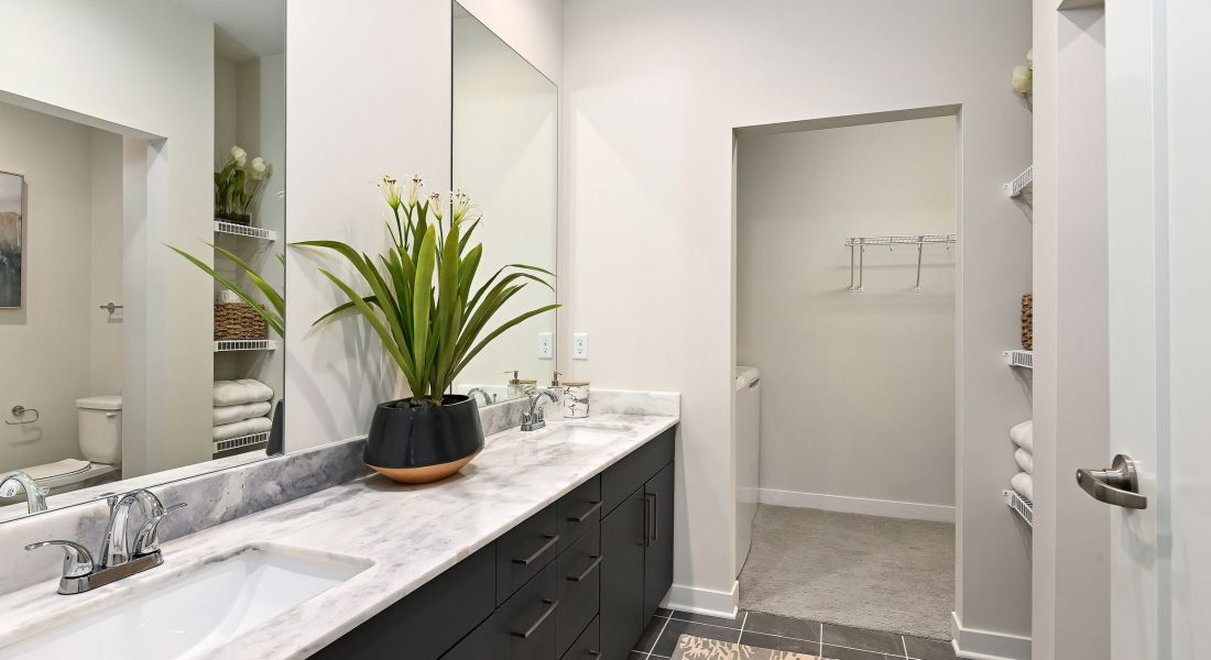 The District Flats apartment bathroom with marble countertops and modern black cabinets